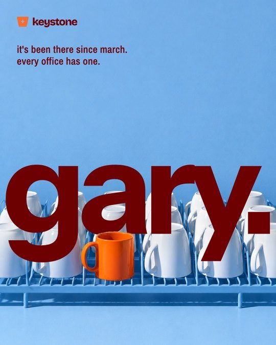 Keystone social post: the word gary behind a rack of white mugs and one orange mug