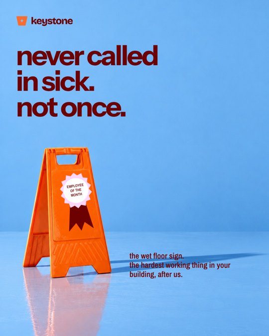 Keystone social post: an orange wet floor sign wearing an award ribbon, never called in sick, not once