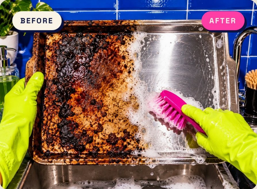Wiped before and after image of a burnt oven tray half scrubbed clean with a pink brush