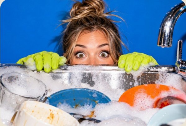 Wiped brand photography: wide-eyed woman in lime gloves peeking over a sink of soapy dishes